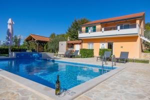a villa with a swimming pool and a house at Villa Marin in Umljanović