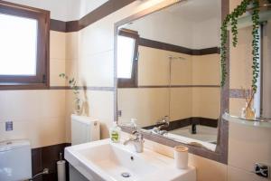 a bathroom with a sink and a mirror and a tub at Vista Mare Aegina in Kipséli +86 photos