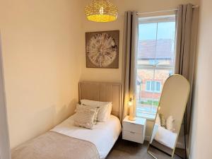 een kleine slaapkamer met een spiegel en een bed bij Modern 4 bedroom property 8 beds wifi smart tv games room pool table in Hull