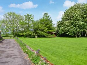 a grassy yard with a path and some flowers at Ivy - Uk47373 in Burgh le Marsh +2 photos
