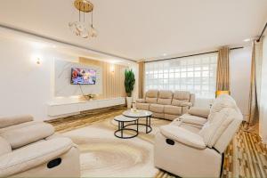 a living room with two couches and a tv at Golden View Manor in Naivasha