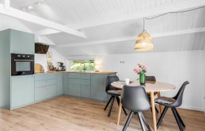 a kitchen with blue cabinets and a table and chairs at 2 Bedroom Beautiful Home In Egernsund in Egernsund