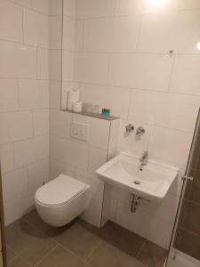 een witte badkamer met een toilet en een wastafel bij Hotel 3H Mannheim in MHG