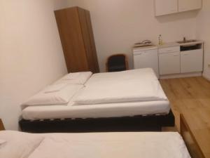 twee bedden in een kleine kamer met een keuken bij Hotel 3H Mannheim in MHG