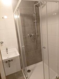 een douche met een glazen deur naast een wastafel bij Hotel 3H Mannheim in MHG