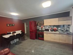 シャーロシュパタクにあるMoonlight Prémium Apartmanházのキッチン(赤い冷蔵庫、テーブル、椅子付) +20枚の写真