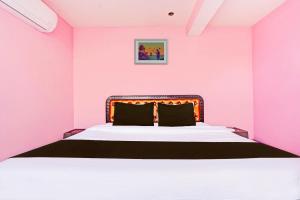 a pink bedroom with a large bed in a room at Hotel O Trinetra Inn in Nagpur