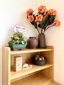 une étagère en bois avec un vase et des fleurs. dans l'établissement Gờ homestay - Giường King - Trung tâm thành phố, à An Khê