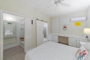 a white bedroom with a bed and a bathroom at Golden View No 107 in Saint James +10 photos