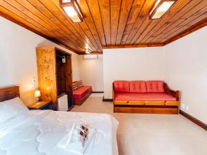 a bedroom with a bed and a red bench at Pousada Charm Canela in Canela