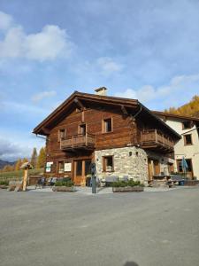 a large wooden building with a balcony on it at Agriturismo Bosco d'oro Livigno in Livigno