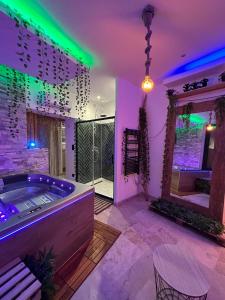 a room with a tub with purple and green lights at Love room - 5 min train station - Jacuzzi - Netflix - Clim in Avignon