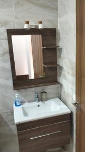une salle de bain avec un lavabo blanc et un miroir dans l'établissement Vacances Soleil Piscine & Plage Bouznika, à Bouznika