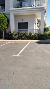 un parking vide devant un immeuble dans l'établissement Vacances Soleil Piscine & Plage Bouznika, à Bouznika