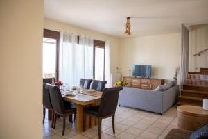 a living room with a table and chairs and a couch at Vista Mare Aegina in Kipséli
