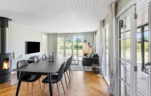 een eetkamer met een tafel en stoelen en een open haard bij Pet Friendly Home In Rødby With Wifi in Kramnitse