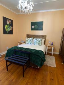 a bedroom with a bed and a chandelier at Die Dorpshuis in Calitzdorp
