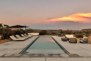 een zwembad met ligstoelen en een zonsondergang bij La Grange by The CoHost Company in Rimrock