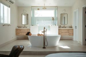 een vrouw in een bad in een badkamer bij La Grange by The CoHost Company in Rimrock