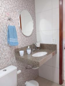 a bathroom with a sink and a mirror and a toilet at Hostel Aldeia Inn in Fortaleza