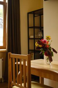 a table with a vase of flowers on it at Saryan Guesthouse in Goris