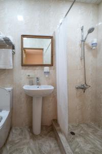 a bathroom with a sink and a toilet and a mirror at Saryan Guesthouse in Goris