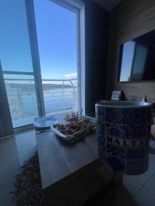 圣保罗湾城SEApartment MALLTA'MR & TAXI FREE的浴室设有水槽和桌上一碗水果