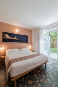 Un dormitorio con una cama grande y una ventana grande. en Alaxia Exclusive Apartments, en Alassio 185 fotos más