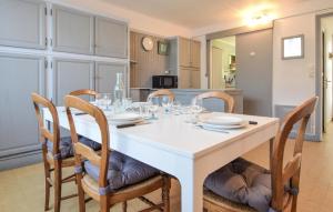 a dining room with a white table and chairs at 3 Bedroom Awesome Home In Cabourg in Cabourg