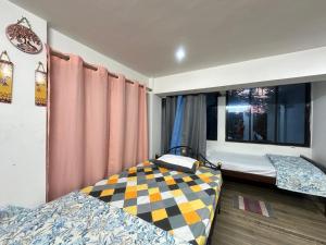 een slaapkamer met twee bedden en een raam bij City Nest Studio in Agartala