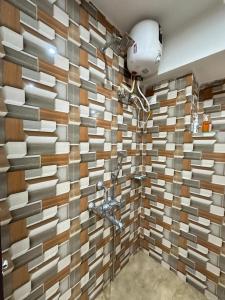 een badkamer met een tegelwand en een douche bij City Nest Studio in Agartala