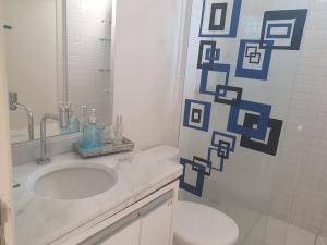 a bathroom with a white sink and a toilet at Luxury Central in Araçatuba +38 photos