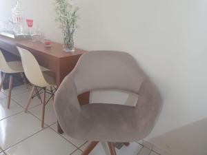 a gray chair sitting next to a wooden table at Luxury Central in Araçatuba