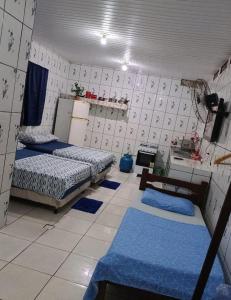 two beds in a room with blue mats on the floor at Cunhas II Áreas COP30 Moskeiro Belém in Belém