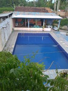 a blue swimming pool in front of a house at Cunhas II Áreas COP30 Moskeiro Belém in Belém