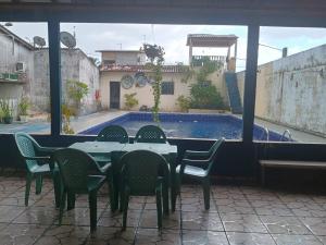 a table and chairs in a patio with a swimming pool at Cunhas II Áreas COP30 Moskeiro Belém in Belém