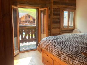 a bedroom with a bed and a large window at Chalet Les Ravaires, Morgins in Troistorrents