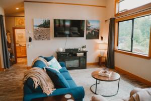 a living room with a blue couch and a tv at Sequim Bay Hideaway in Sequim