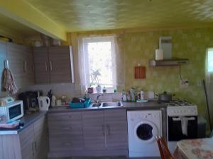 a kitchen with a sink and a washing machine at Комната in Wakefield +1 photo