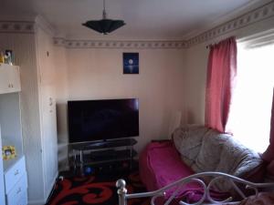 a living room with a couch and a flat screen tv at Комната in Wakefield