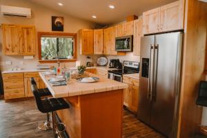 a kitchen with wooden cabinets and a stainless steel refrigerator at Sequim Bay Hideaway in Sequim +18 photos