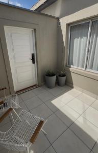 a patio with a white door and a bench and plants at Andina Apart - Calm in the heart of Mendoza in Mendoza