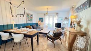 a living room with a dining table and chairs at Jolie maison avec jardin à proximité de la plage in Saint-Clément-des-Baleines
