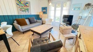 a living room with a couch and a table at Jolie maison avec jardin à proximité de la plage in Saint-Clément-des-Baleines