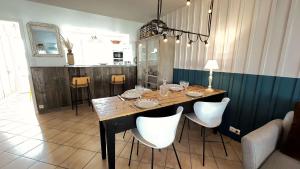 a dining room table with white chairs around it at Jolie maison avec jardin à proximité de la plage in Saint-Clément-des-Baleines +4 photos
