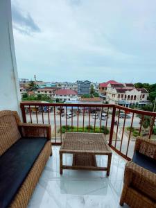een balkon met een bank en een tafel bij Apartments in Town in Zanzibar City