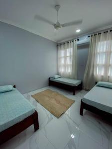 een slaapkamer met 2 bedden, een bank en een tapijt bij Apartments in Town in Zanzibar City