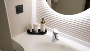 马尔萨克Hôtel OstOria Périgueux, BW Signature Collection的浴室水槽,配有1瓶肥皂和1面镜子 更多50张照片