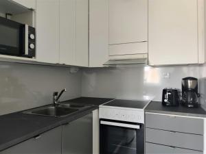 a kitchen with a sink and a stove at Convenient Apartment for 2 with Sauna in Kemi +6 photos