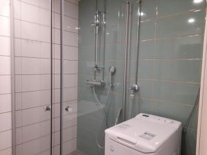 a bathroom with a shower with a toilet and a glass shower stall at Convenient Apartment for 3 in Oulu